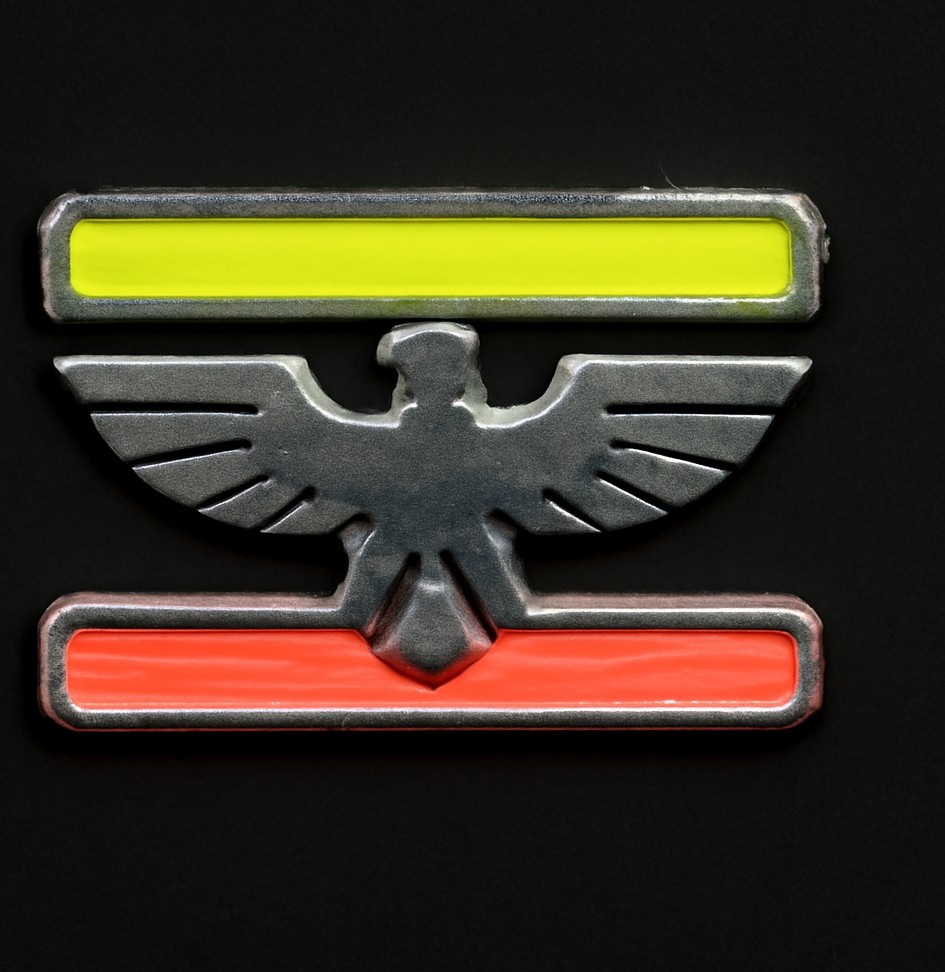 A chrome badge of a heraldic eagle facing forward, wings spread, wedged between a glowing neon-green bar above and a red bar below, on a dark charcoal background